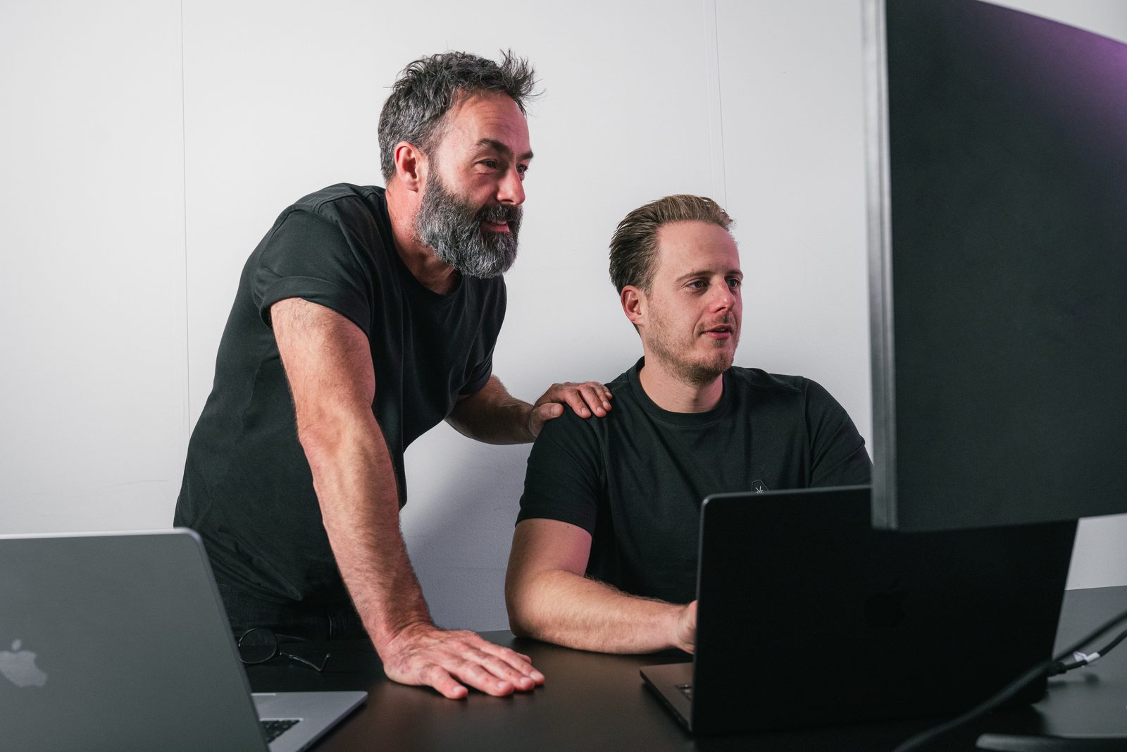 Ivo Klink staat met een hand op de schouder van Maurits den Dunnen en samen kijken ze naar het scherm van een laptop